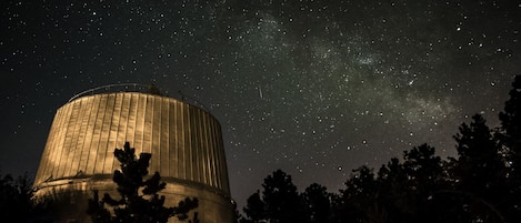 A large observatory dome with a starry night sky visible through its opening.