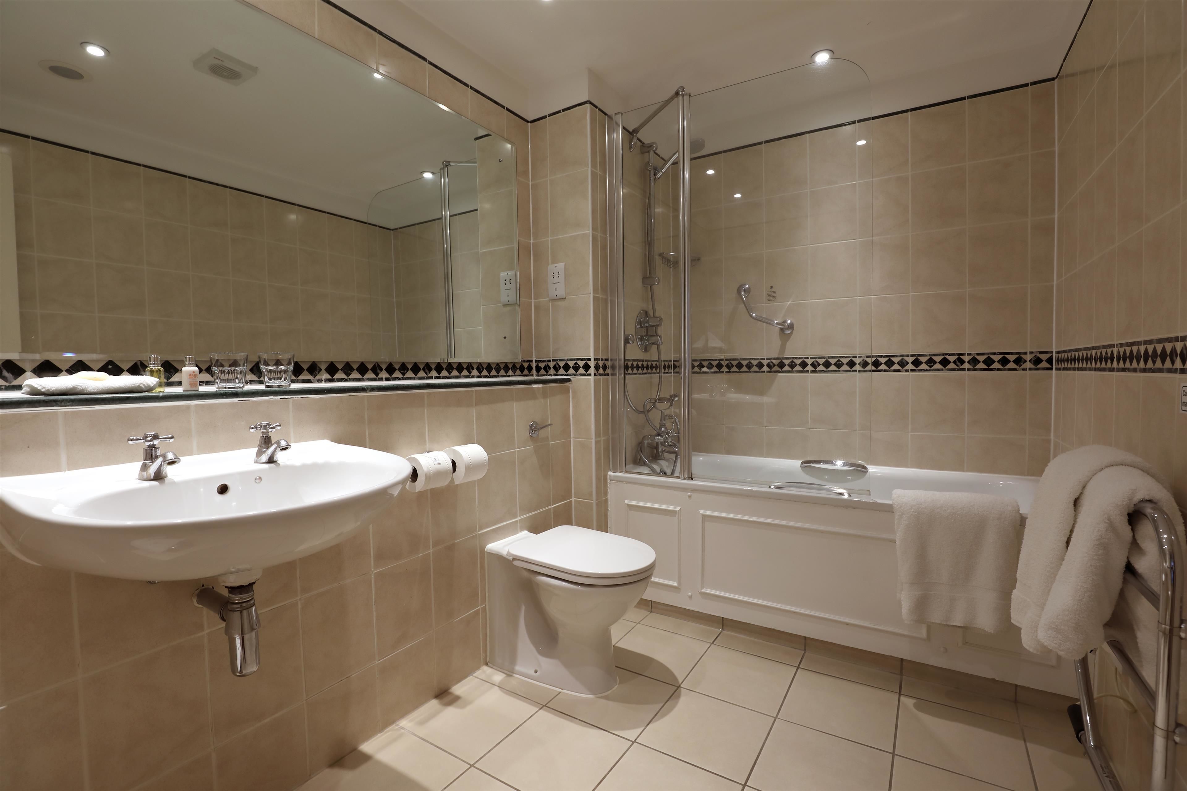 A modern bathroom with a sink, toilet, and bathtub.