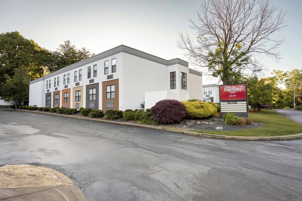 A modern hotel building with a sign for Red Roof Inn & Suites.