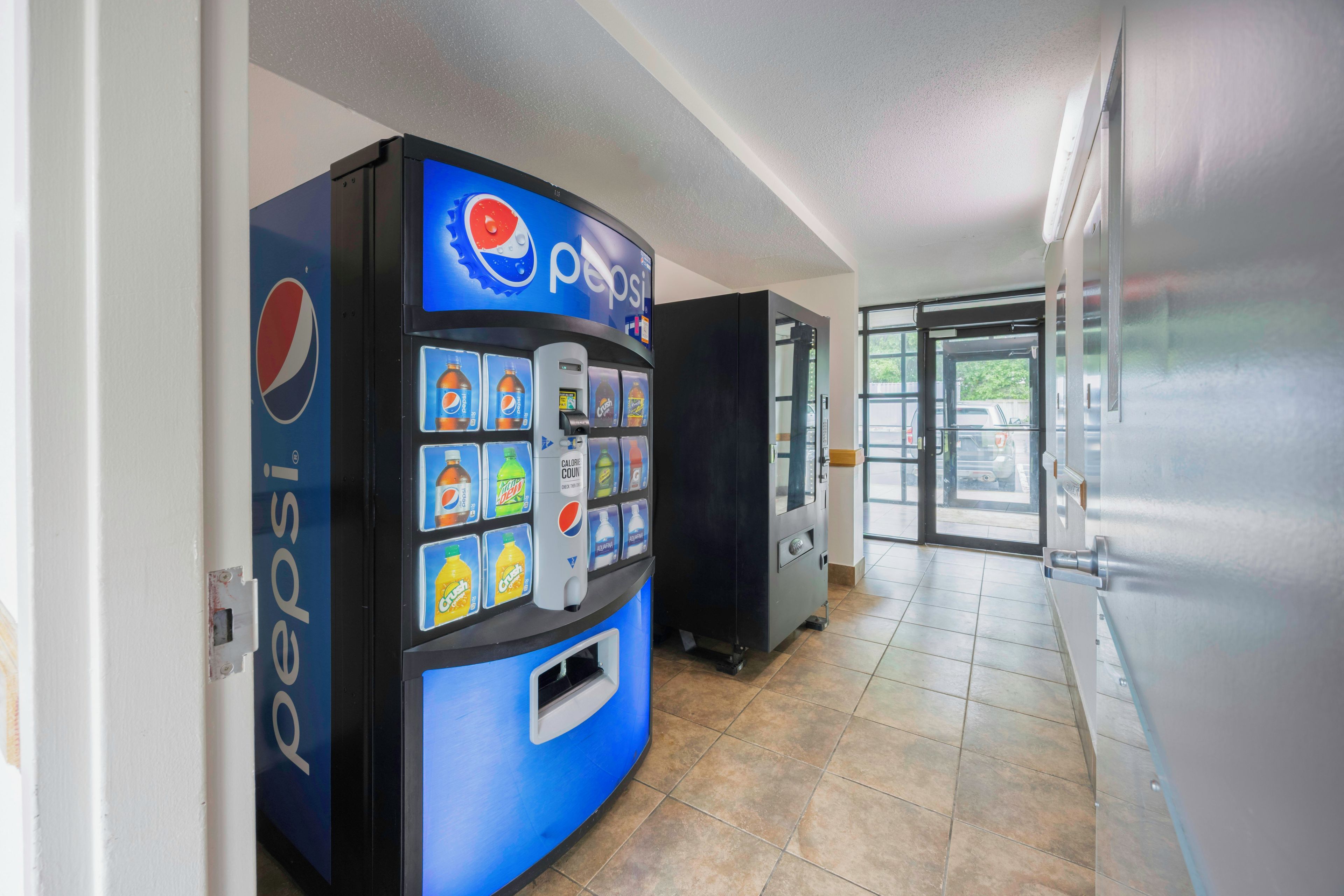 Ein Getränkeautomat mit Pepsi-Logo, verschiedenen Getränkeauswahlen und einem Münzfach.