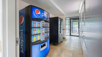 Un distributeur automatique orné du logo Pepsi, proposant une variété de boissons et muni d’un compartiment pour les pièces de monnaie.