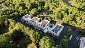 Un edificio grande con varios espacios de estacionamiento y un área verde circundante.