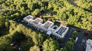 Un edifici gran amb diverses places d'aparcament i una zona verda al voltant.
