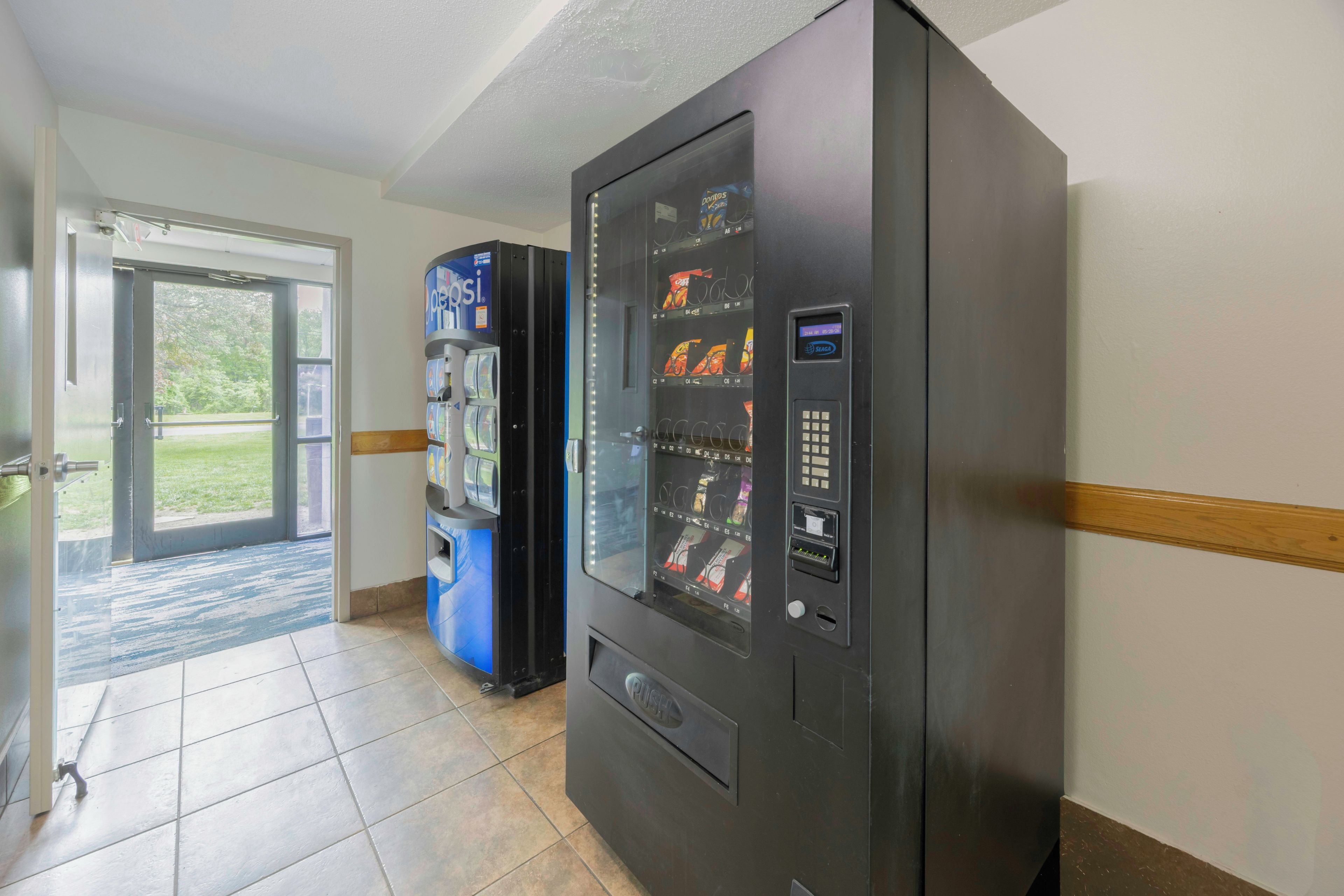 A vending machine with a selection of snacks and a push button interface.