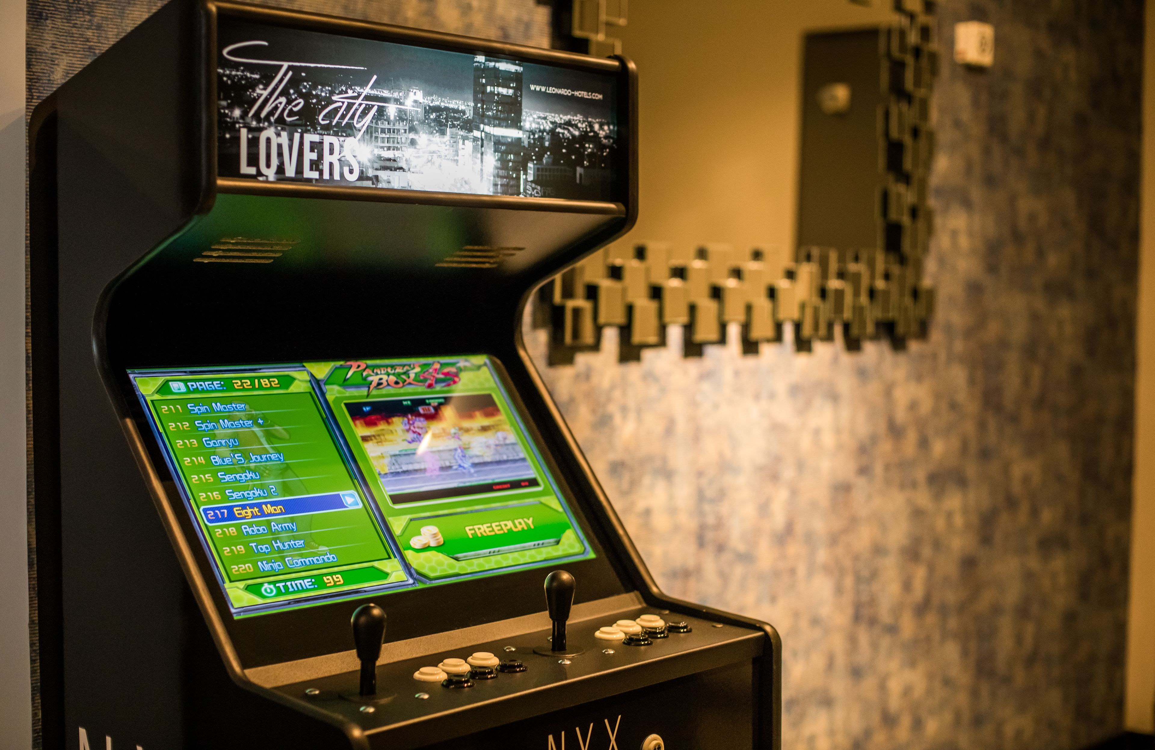 Una máquina tragamonedas con una pantalla que muestra opciones de juego y un fondo con un paisaje urbano.