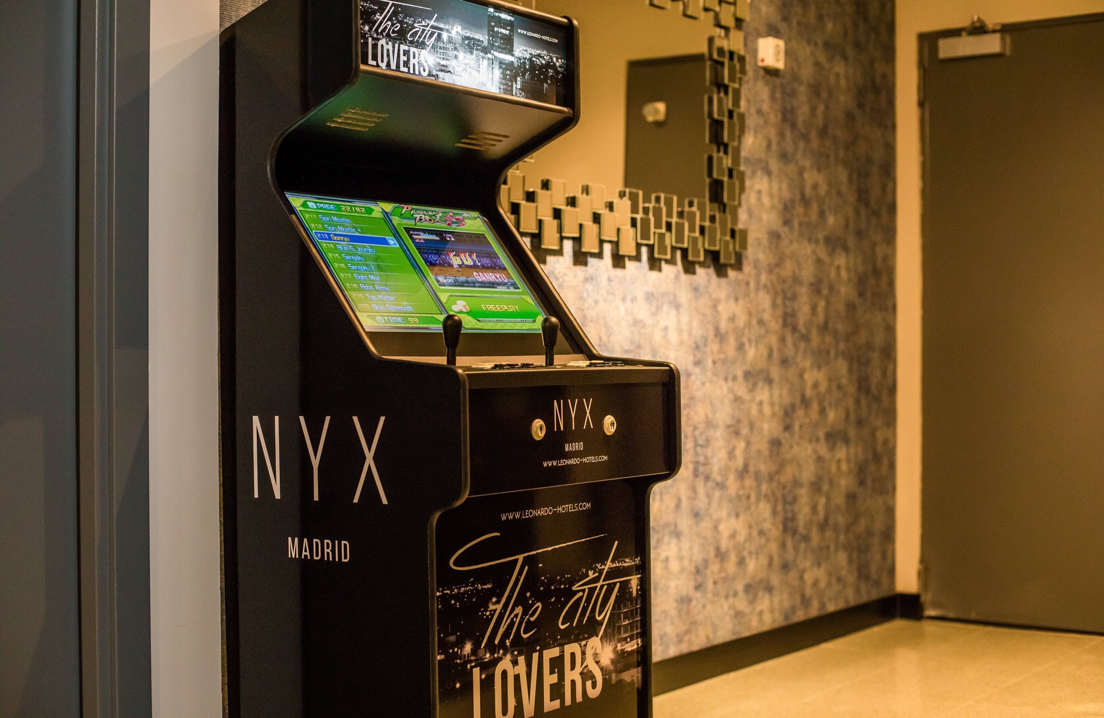 Quiosco de hotel NYX Madrid con pantalla táctil y un letrero que dice 'The City Lovers'.