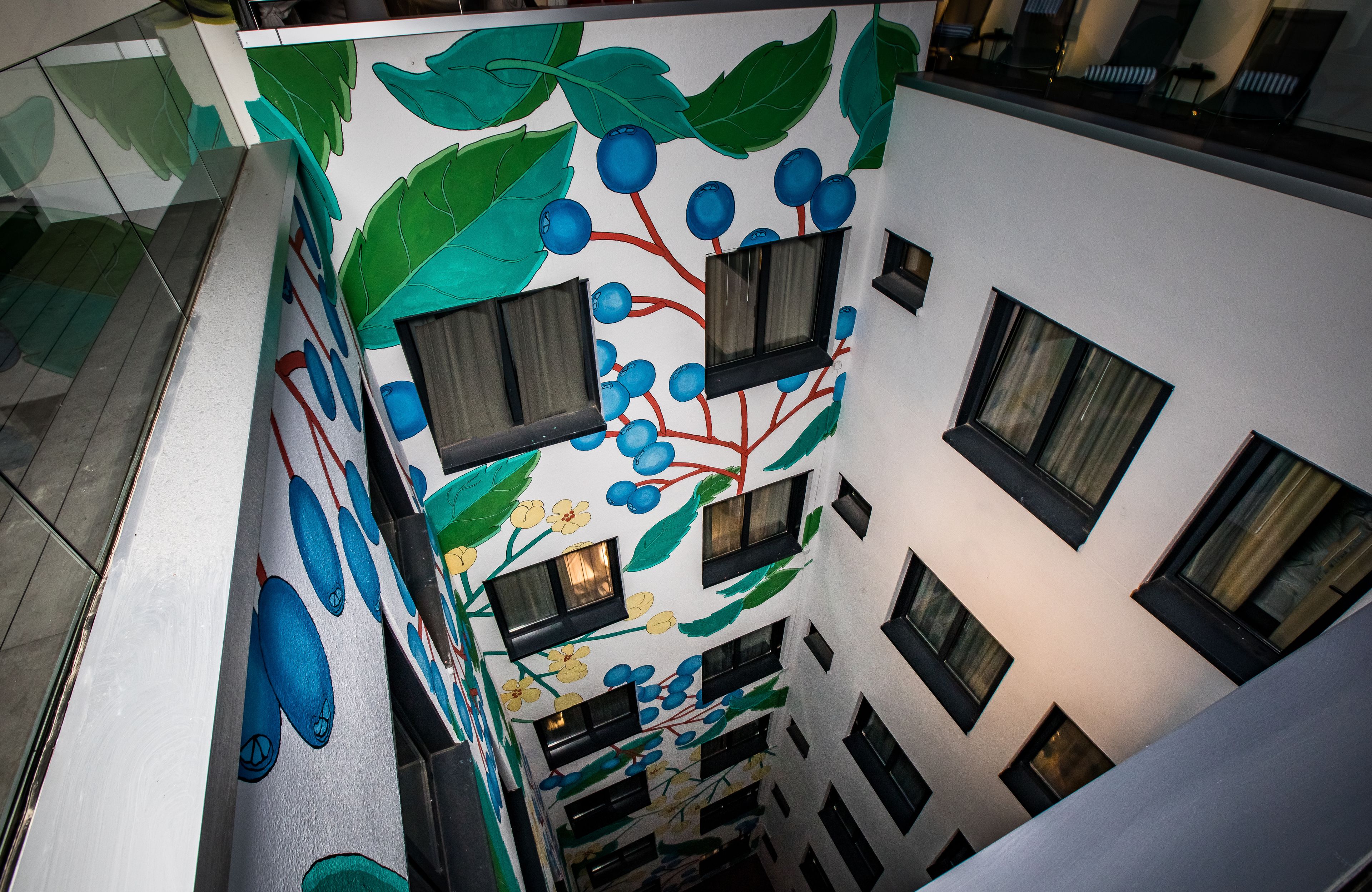 A multi-level building with a mural of fruit and leaves on the exterior wall.