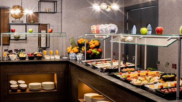 A buffet with various food items and a glass display case.