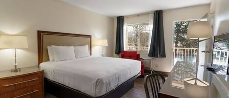 A hotel room with a bed, bedside tables, a desk, a chair, and a window with curtains.
