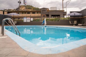 Una piscina al aire libre, sillones reclinables de piscina