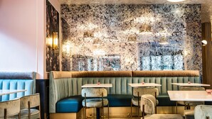 A restaurant interior with booths, tables, and a textured wall. - Copley Square Hotel, a FOUND Hotel (Boston)