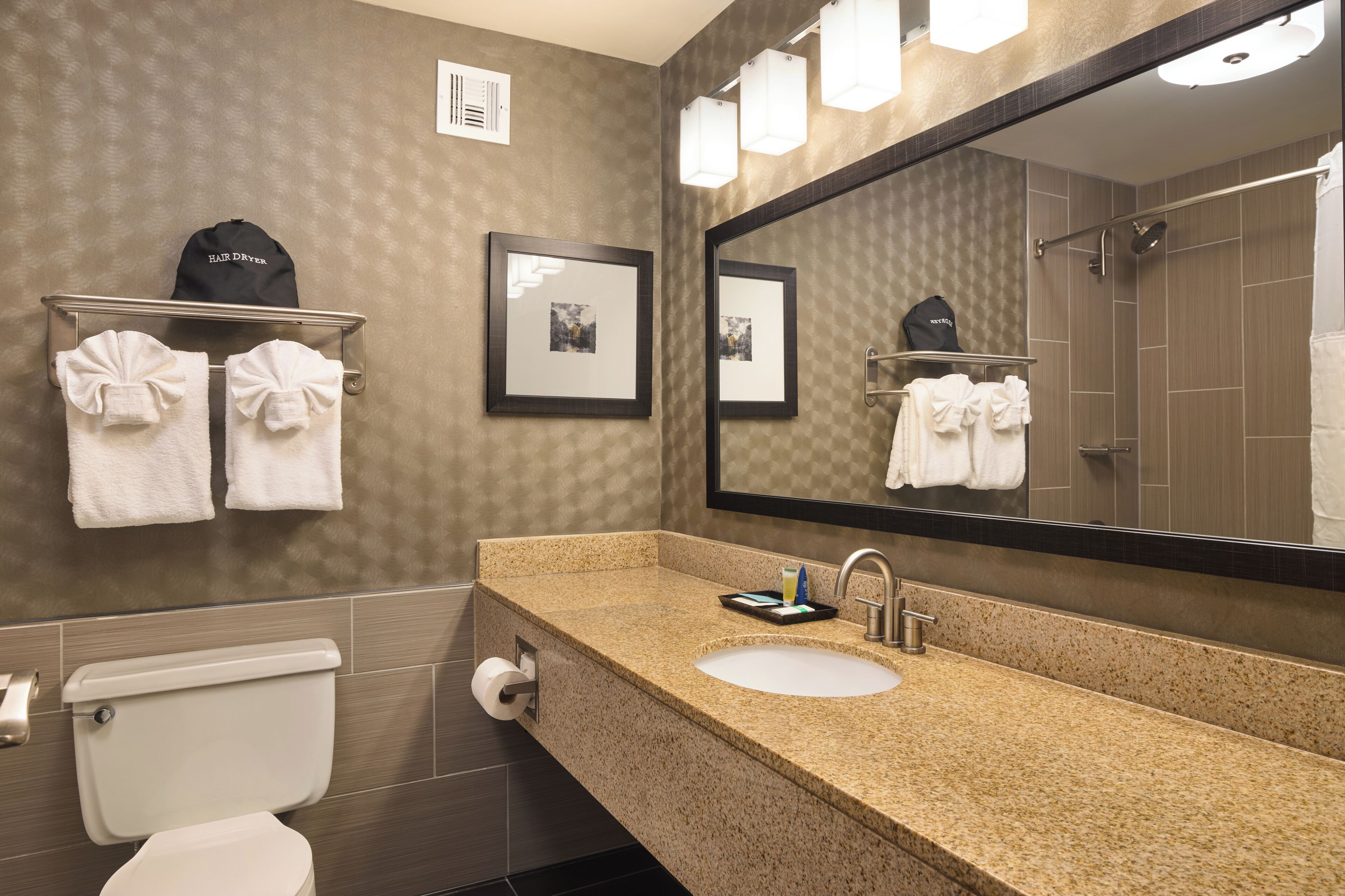 A bathroom with a sink, mirror, towel rack, and toilet.