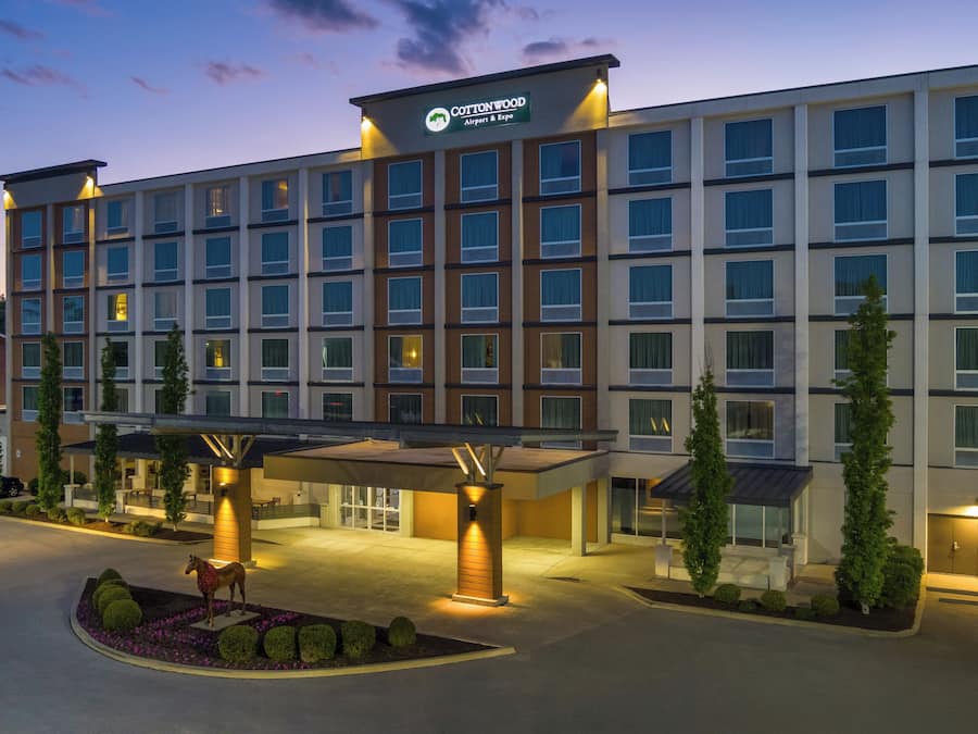 Um hotel com vários andares e uma placa com a inscrição 'Cottonwood Airport & Expo'.