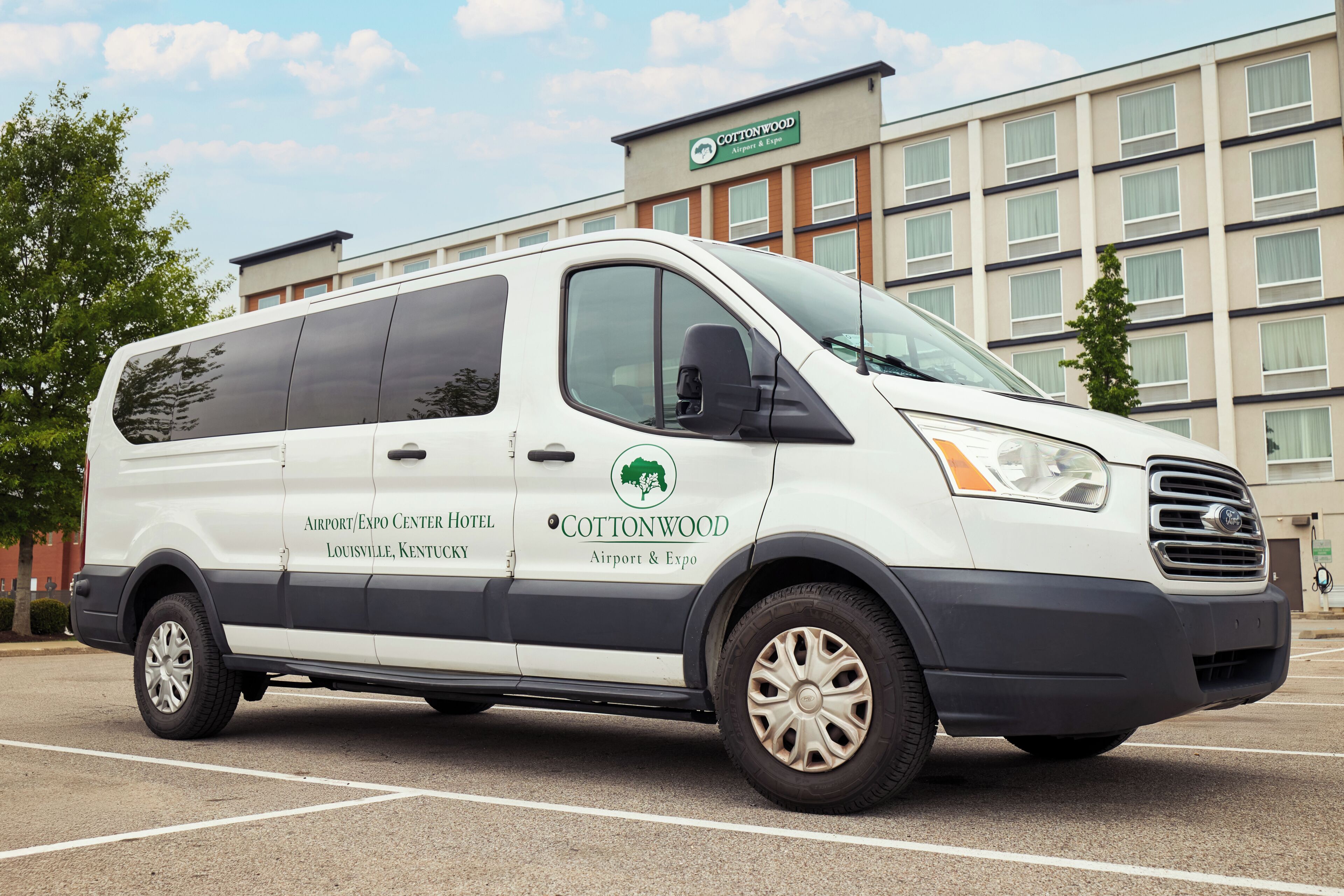 A white van with 'Cottonwood Airport & Expo' branding parked in a lot.