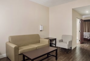 Una habitación con un sofá, una mesita y una silla.