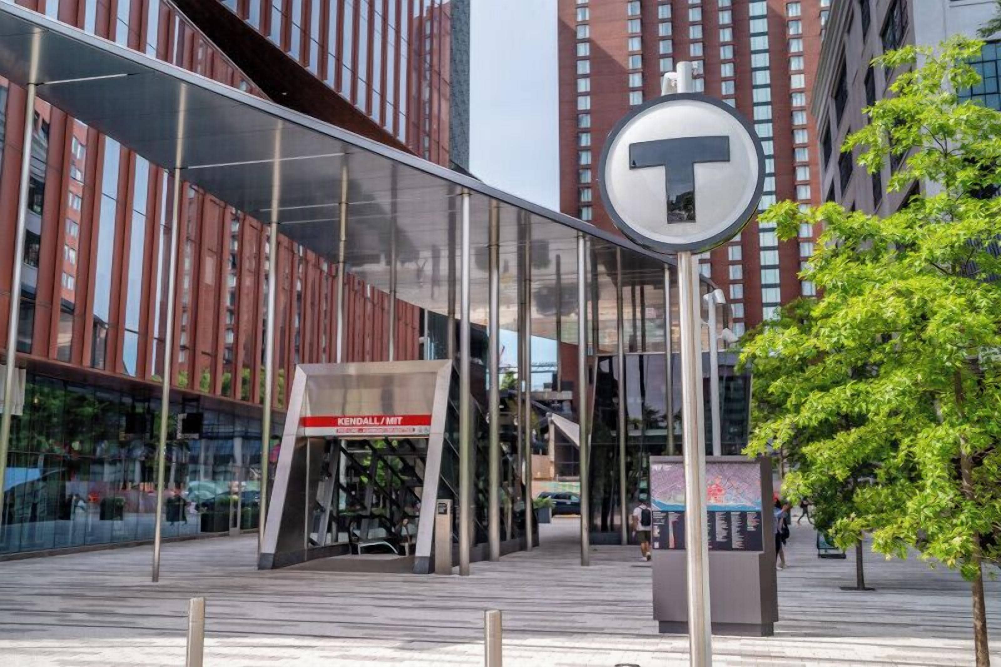 Un edificio moderno con facciata in vetro e un cartello ben visibile con il logo 'T' e la scritta 'KENDALL/MT'.