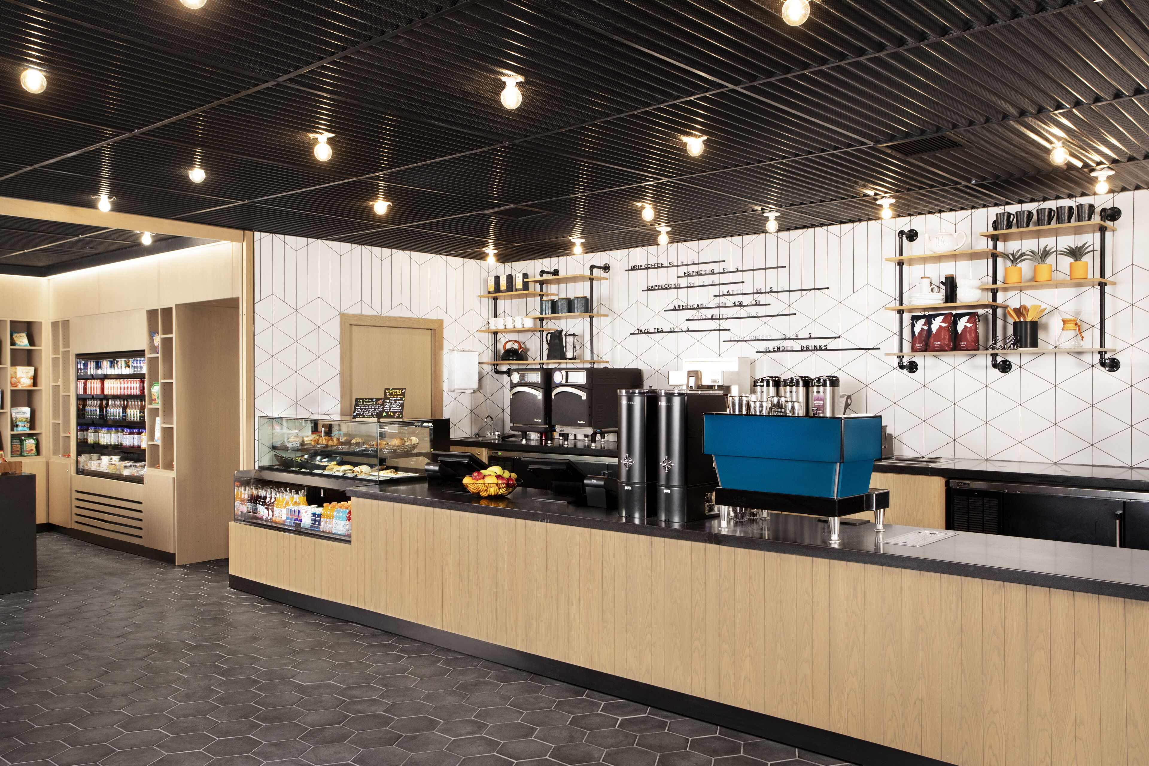 A modern coffee shop interior with a counter, coffee machines, and shelves with coffee products.