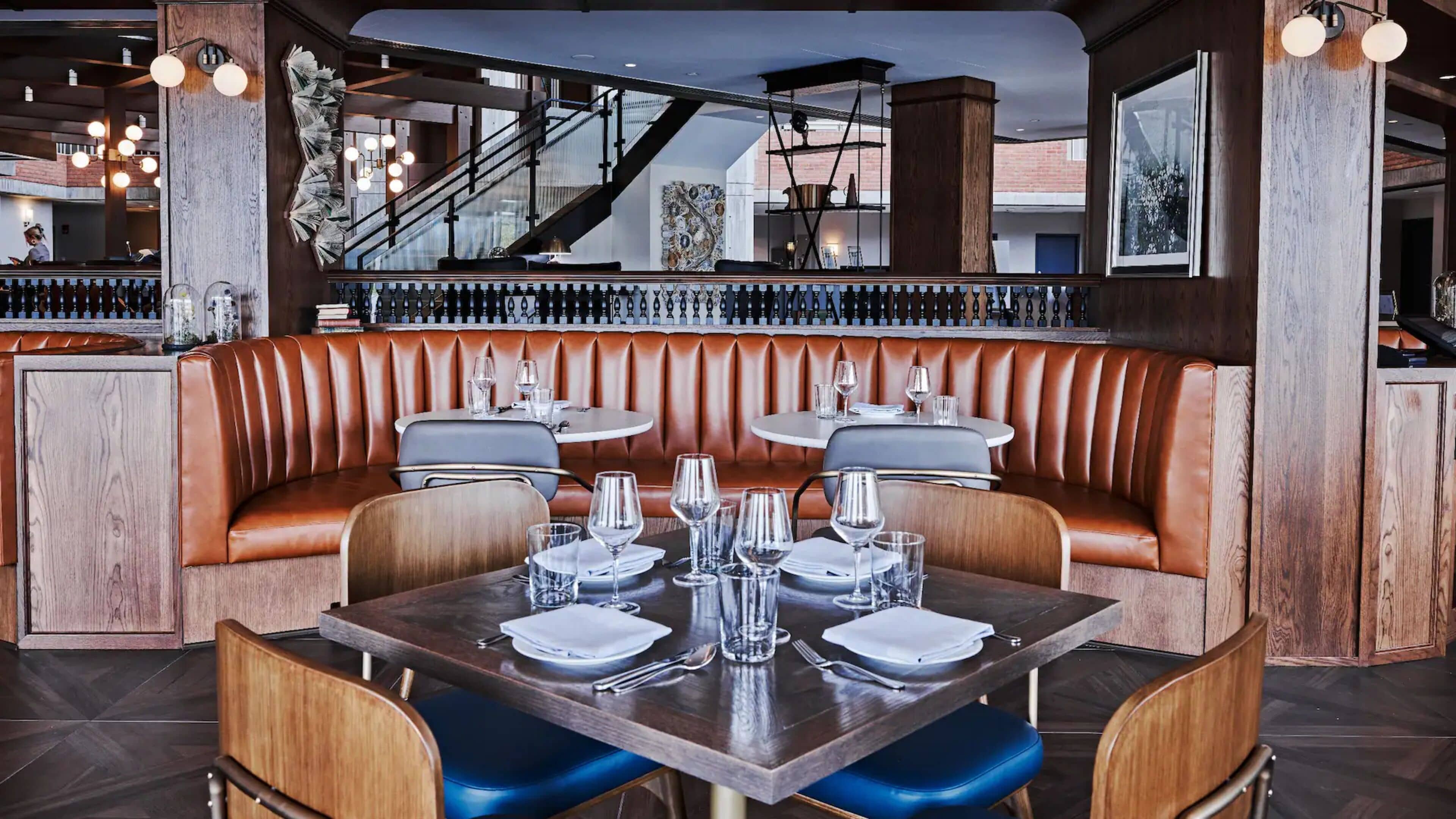 En restaurant med båse og borde, samt trappe og udsigt ud