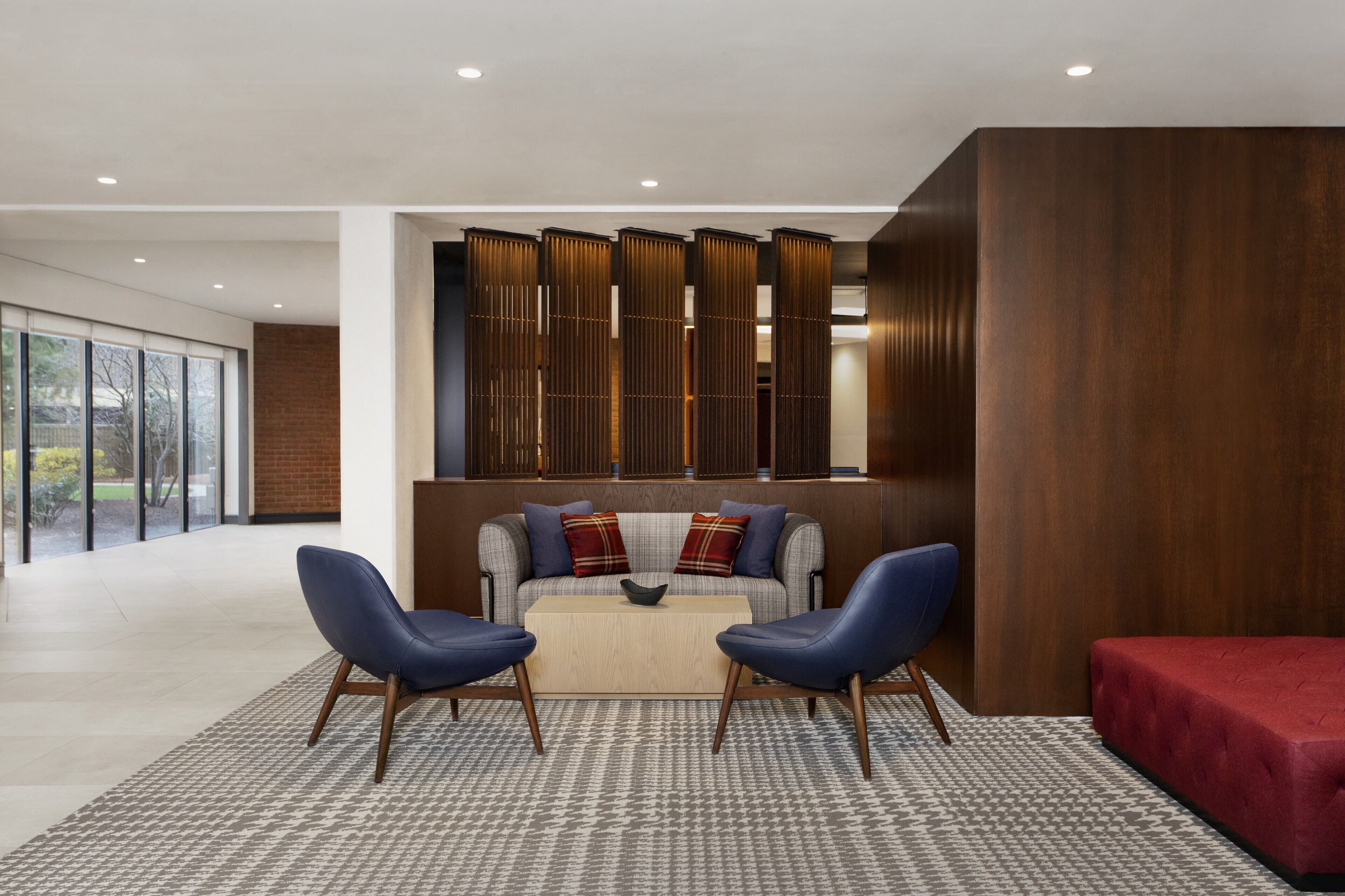 Un salon moderne comprenant un canapé, deux fauteuils, une table basse et un canapé rouge.
