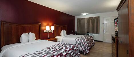 Een hotelkamer met twee bedden, een televisie en een bureau.