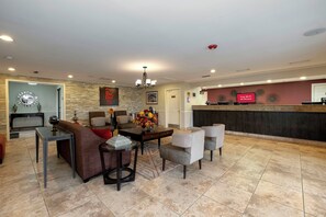 A hotel lobby with a reception desk, seating area, and a chandelier. - Red Roof Inn Dothan (Dothan)