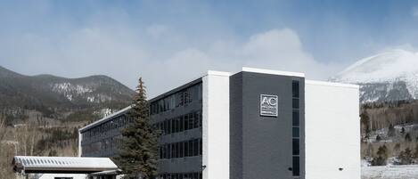 A modern building with a flat roof, large windows, and a sign reading "AC".