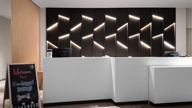 A reception area with a modern design, featuring a large, illuminated wall panel and a reception desk. - AC Hotel Frisco Colorado (Frisco)