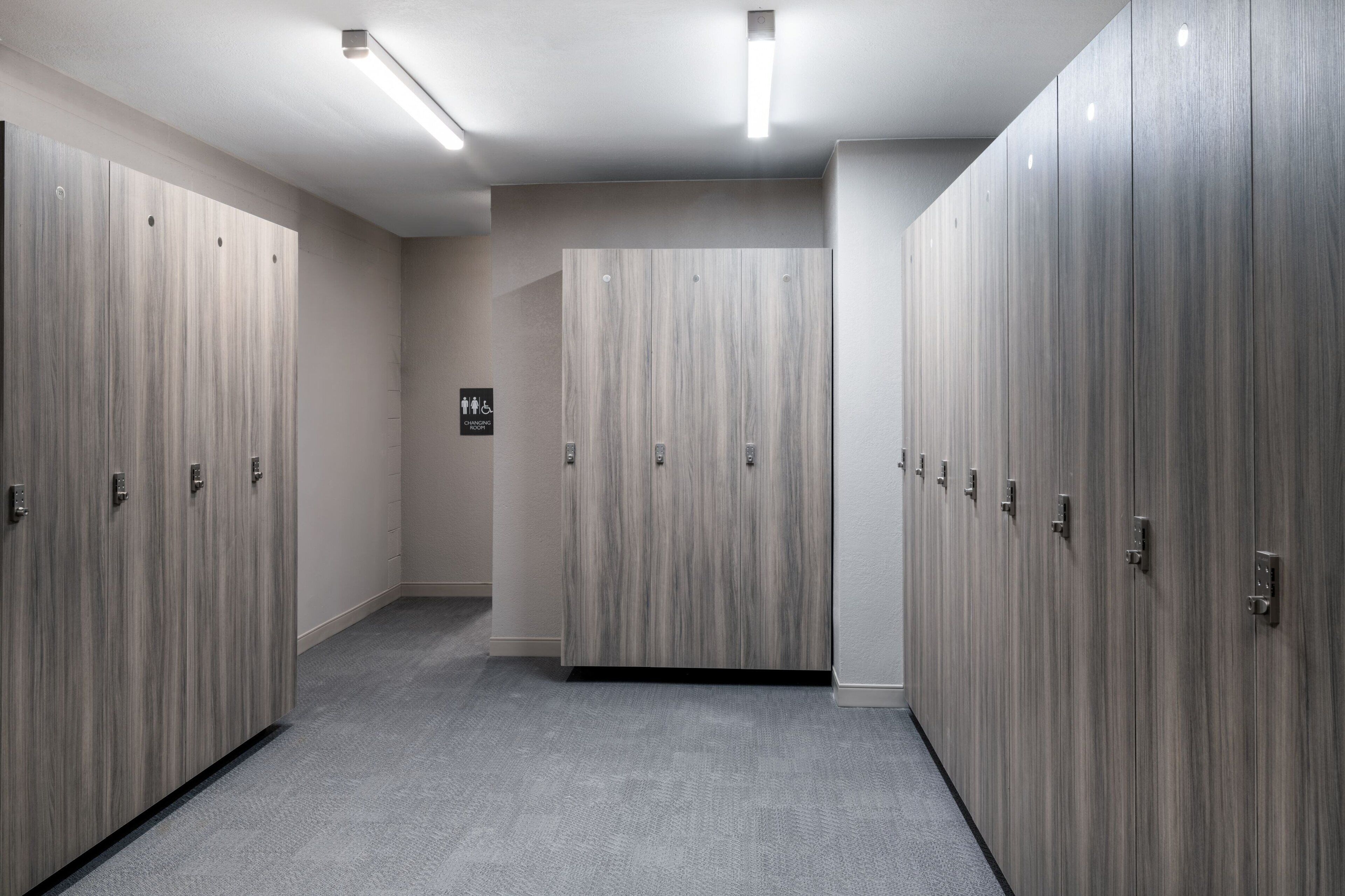 A hallway with lockers, a wheelchair accessibility sign, and a clean, modern design.