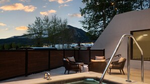 A rooftop terrace with a hot tub, wicker chairs, and a view of mountains and a lake. - AC Hotel Frisco Colorado (Frisco)