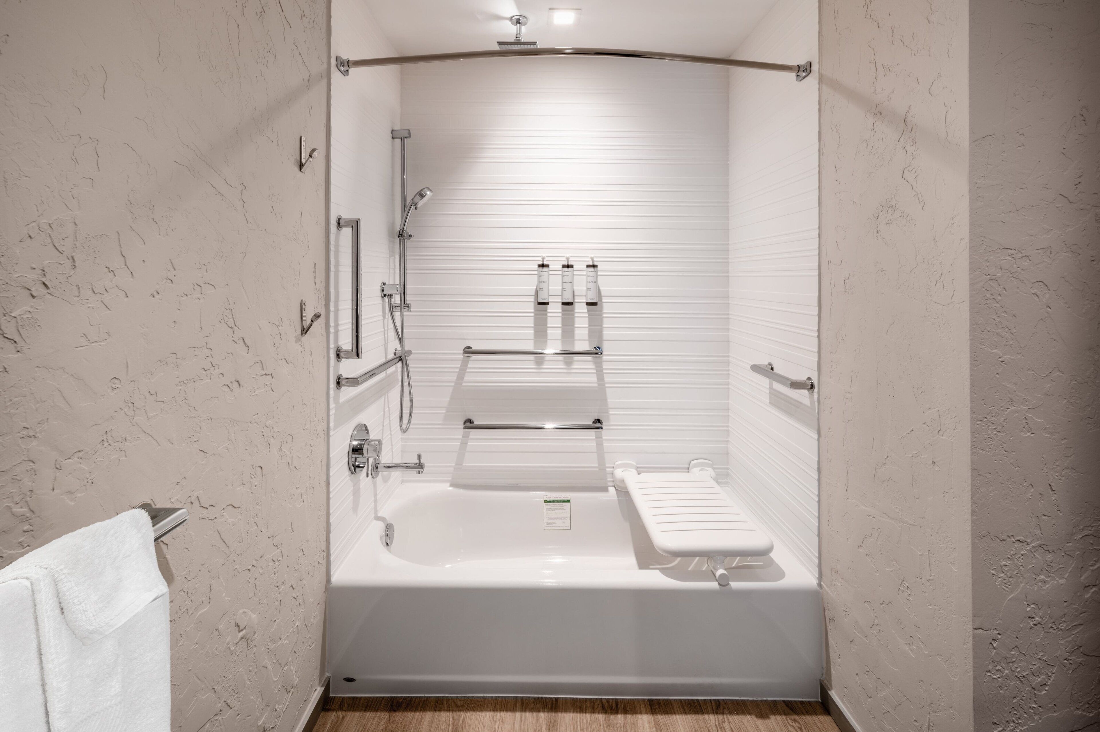A modern bathroom with a bathtub, a shower, and a toilet.