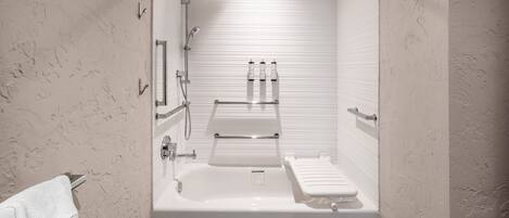 A modern bathroom with a bathtub, a shower, and a toilet.
