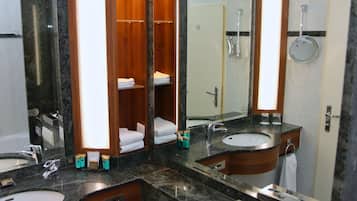 Ein modernes Badezimmer mit zwei Waschbecken, einem großen Spiegel und einer Duschkabine.