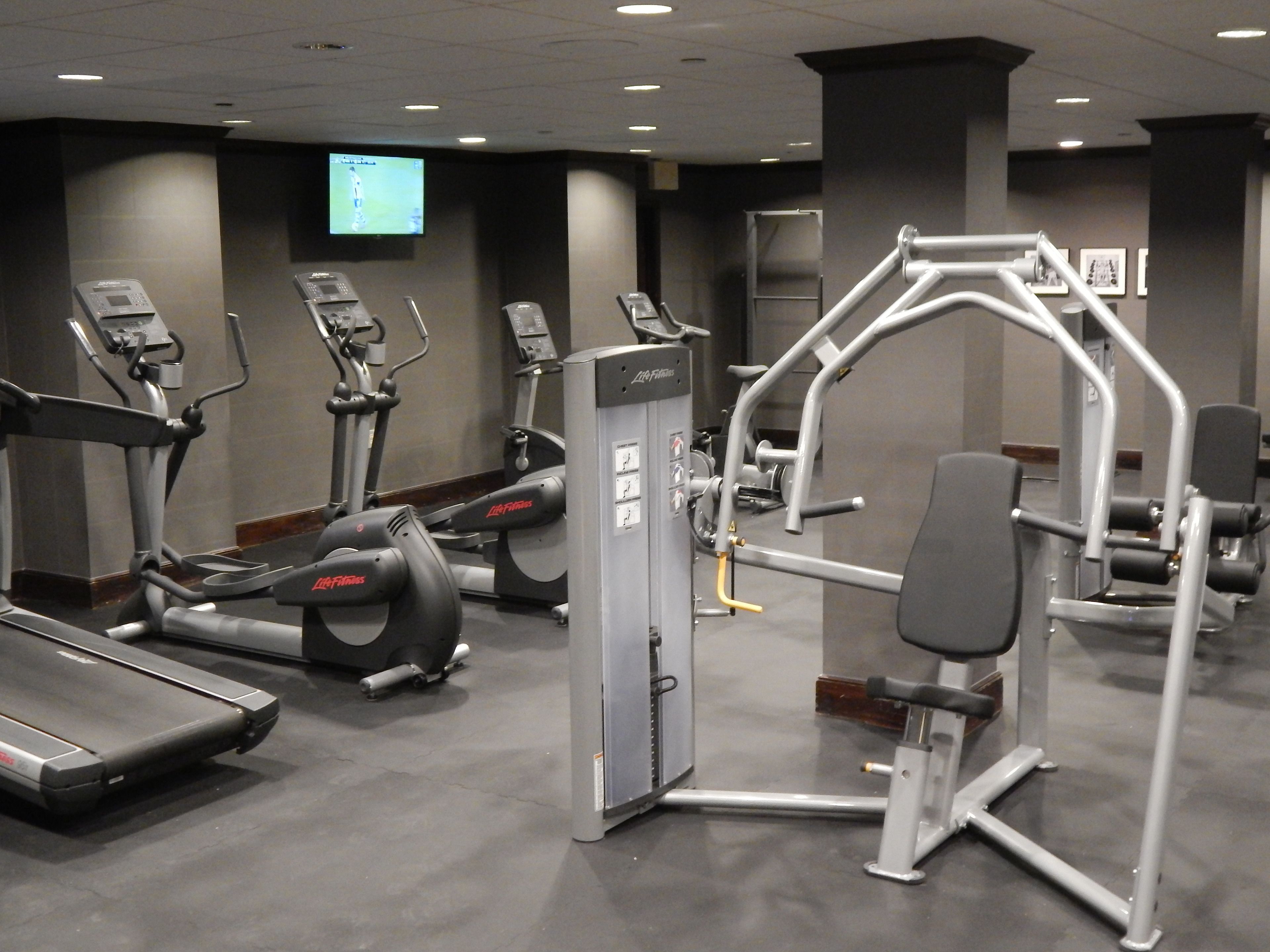 A gym with treadmills, elliptical machines, and weight equipment.