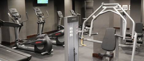 A gym with treadmills, elliptical machines, and weight equipment.