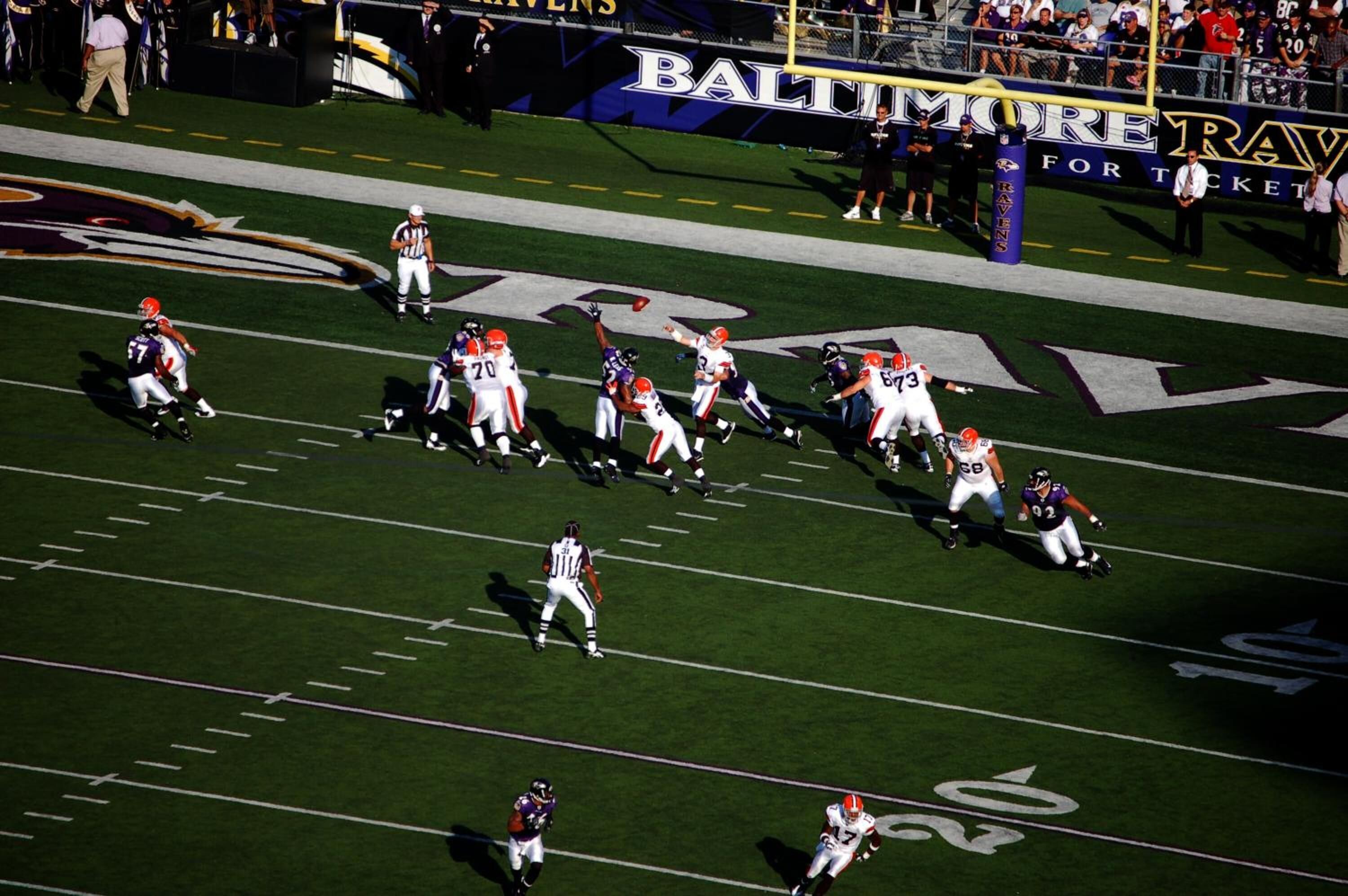 A football stadium with a large crowd and players on the field.