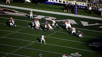 A football stadium with a large crowd and players on the field.