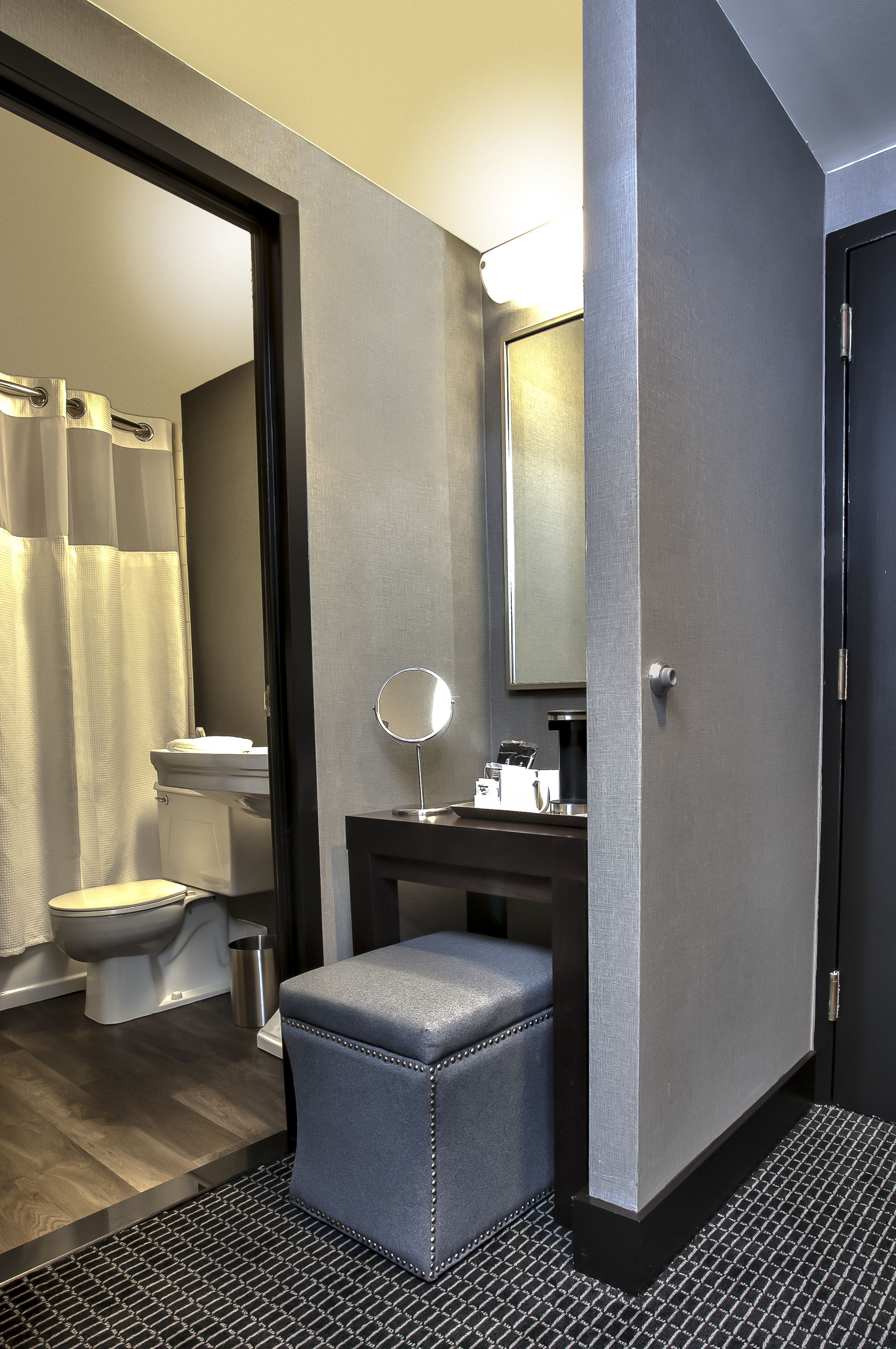 A modern bathroom with a toilet, sink, and mirror.