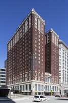 Un gran edificio hotelero de estilo arquitectónico clásico, con varios pisos y una entrada de esquina destacada.