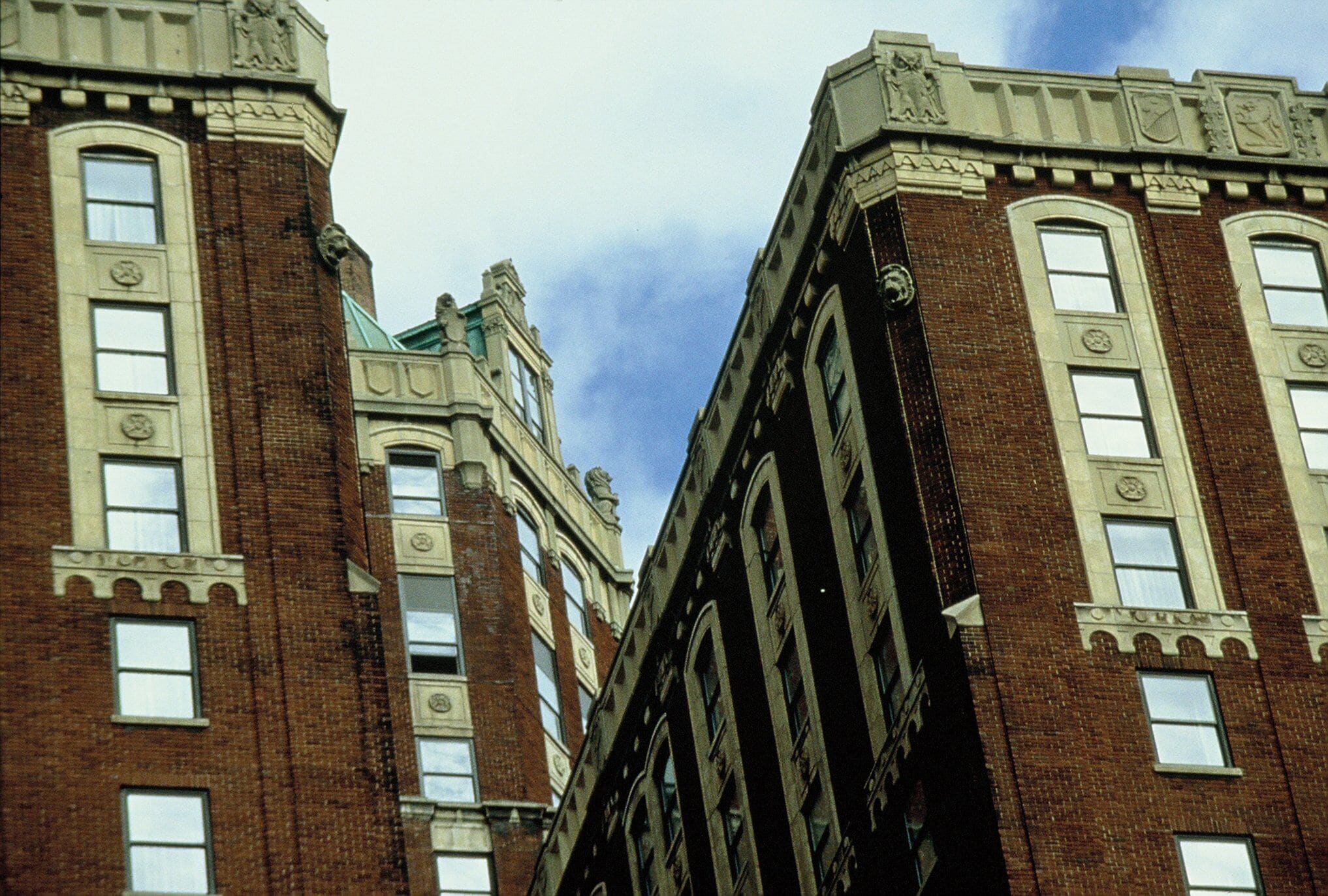 Un edificio alto e histórico con numerosas ventanas y detalles arquitectónicos decorativos.