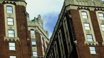 Un edificio alto e histórico con numerosas ventanas y detalles arquitectónicos decorativos.