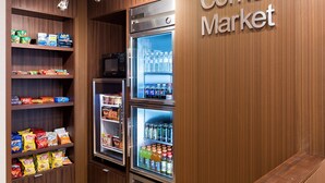 A Corner Market with shelves stocked with snacks and beverages, and a refrigerated section. - Fairfield Inn and Suites by Marriott Austin South (Austin)