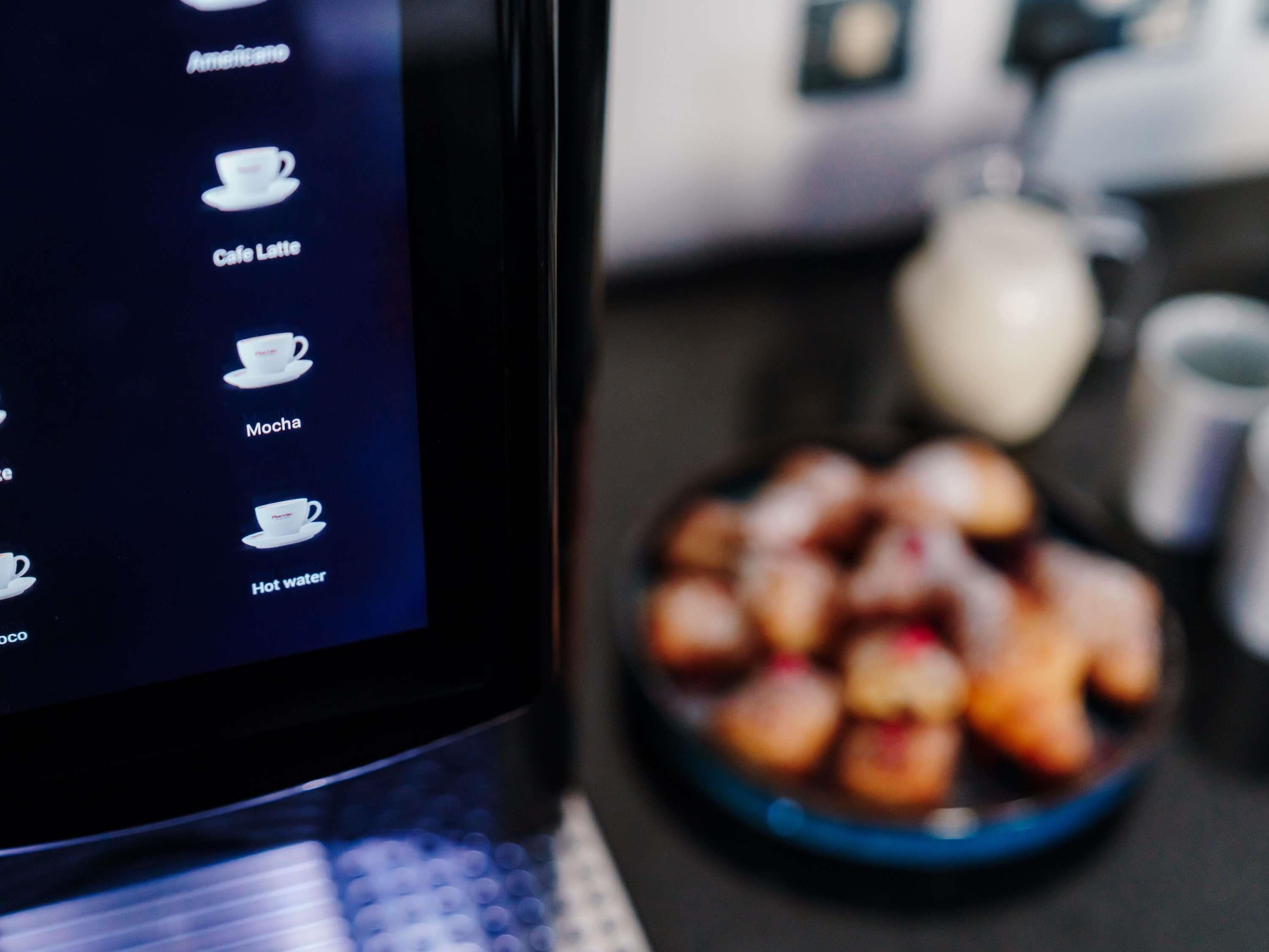 Ein Tablet, das eine Speisekarte mit Optionen wie Americano, Café Latte, Mokka und heißem Wasser zeigt.