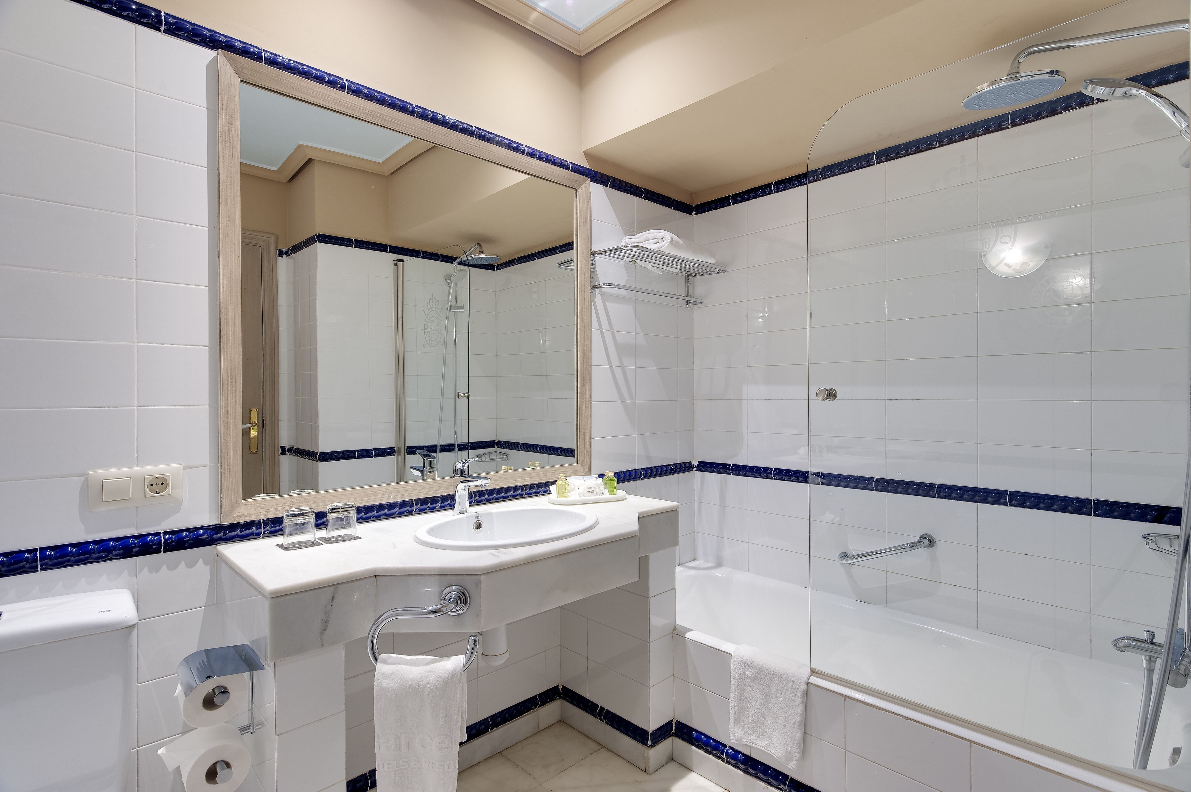 A modern bathroom with a white sink, mirror, and bathtub.