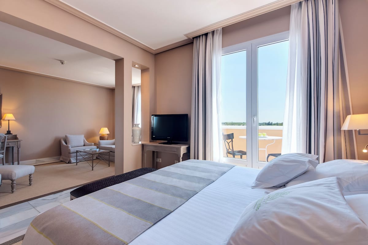 A hotel room with a bed, a TV, a desk, and a chair.