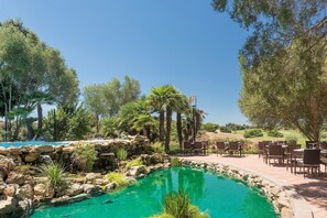 Relax by the serene pool surrounded by natural rock formations and lush greenery.