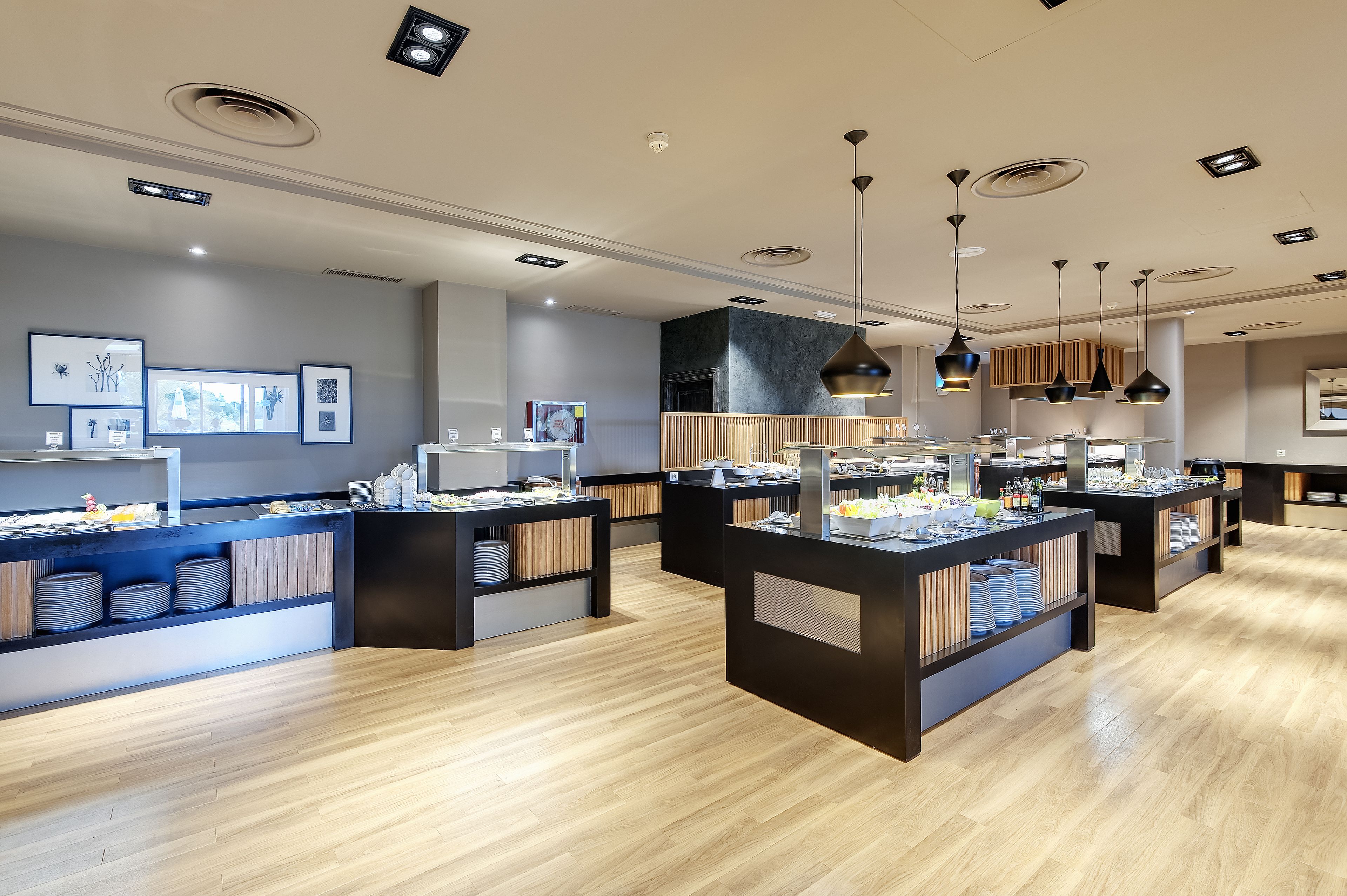 Een modern café met houten vloeren, zwart-wit decoratie en hanglampen.