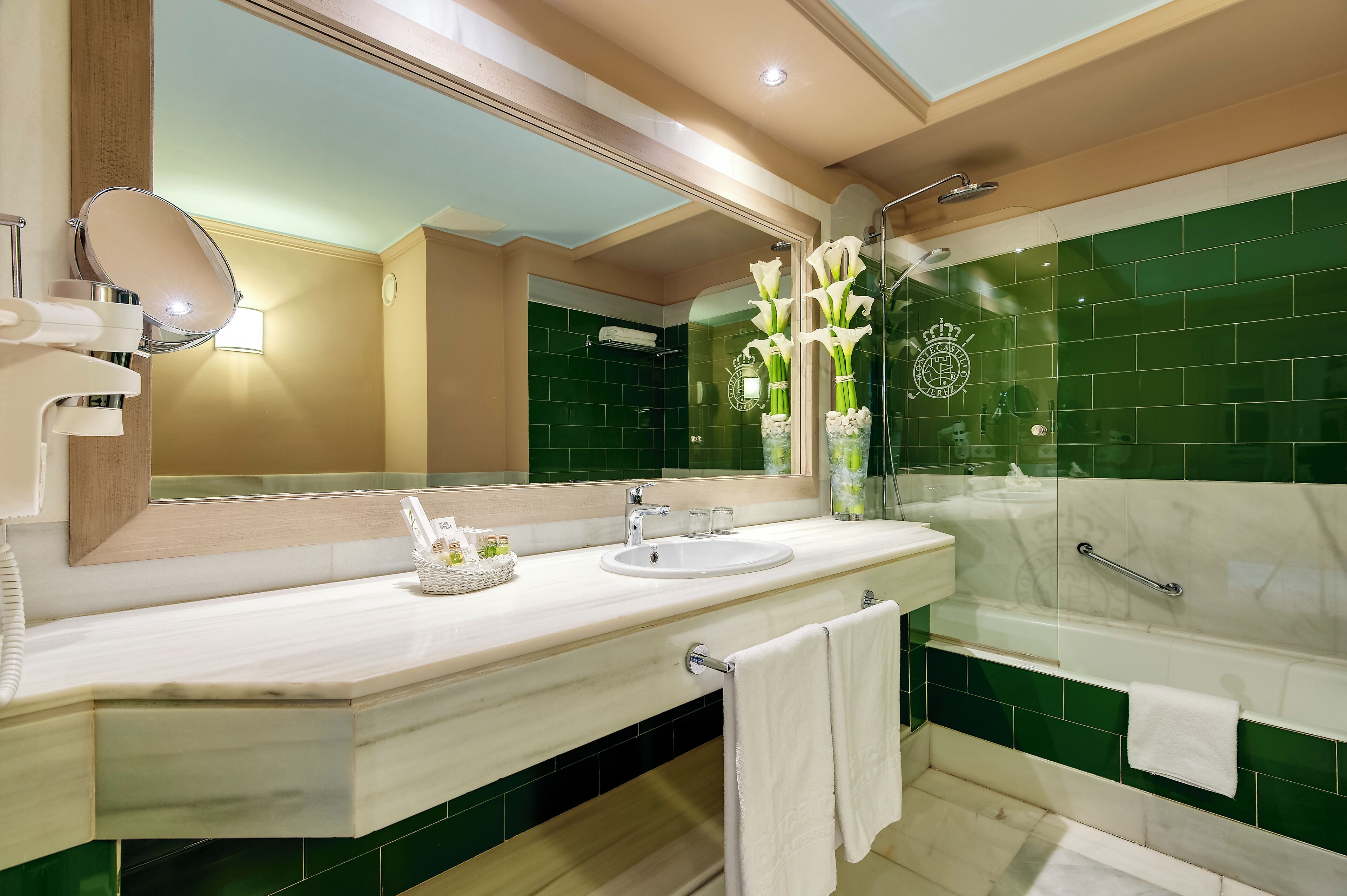 Un baño con lavamanos, espejo y bañera.
