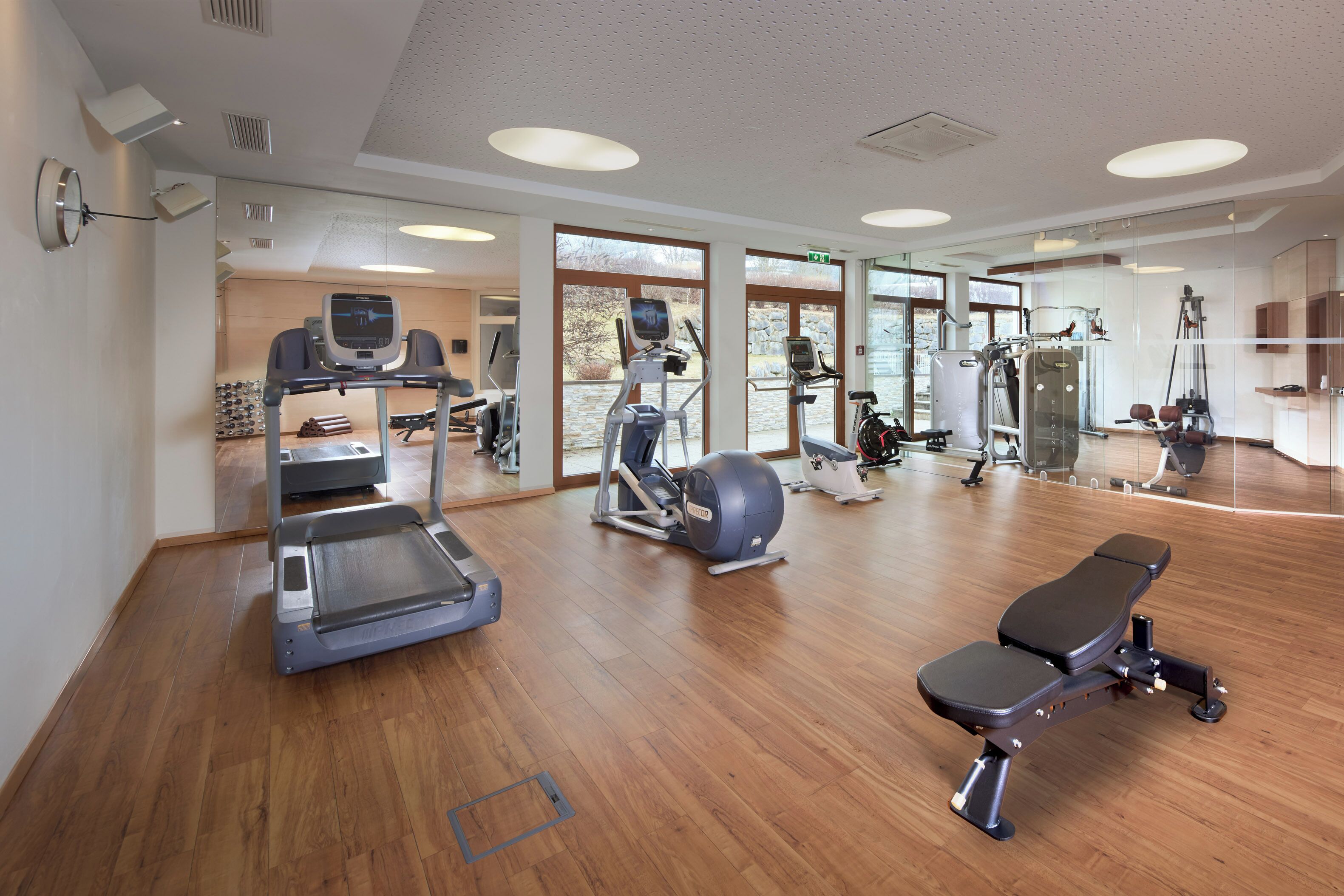 Une salle de sport équipée de tapis de course, de vélos elliptiques et d'appareils de musculation.