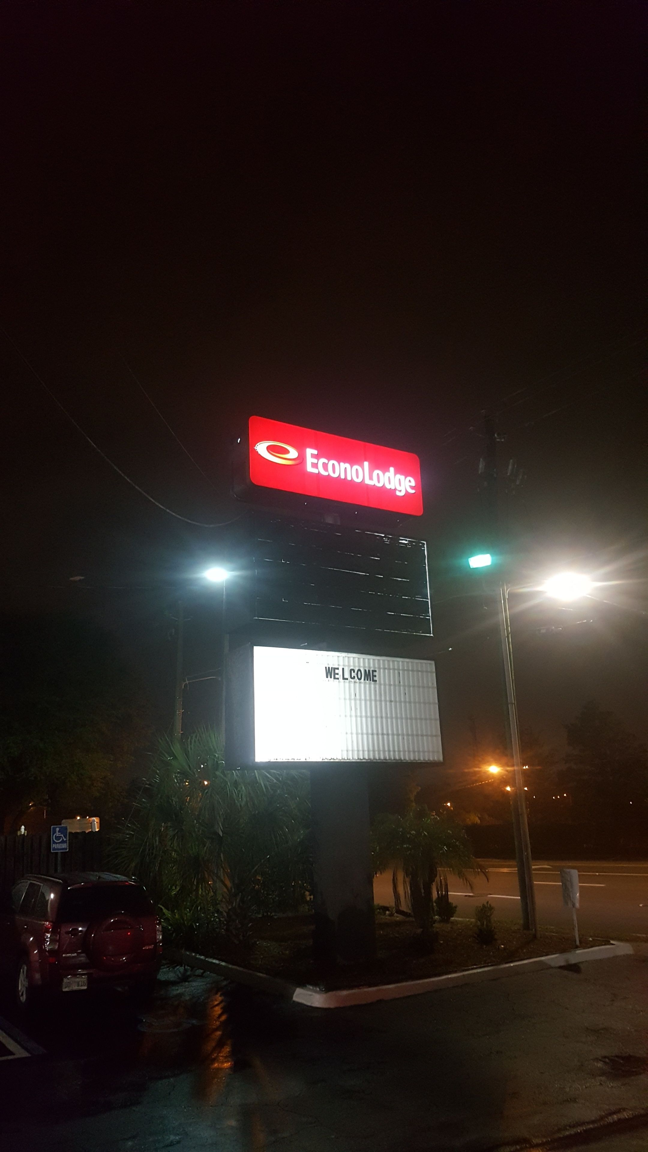 Een grote verlichte reclamebord voor EconoLodge met een welkomstboodschap.