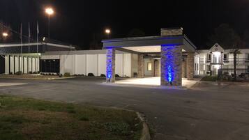 A hotel entrance with a stone pillar and a covered walkway.